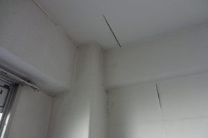 断熱リフォーム前の寝室　結露で天井・壁のクロスがはがれている